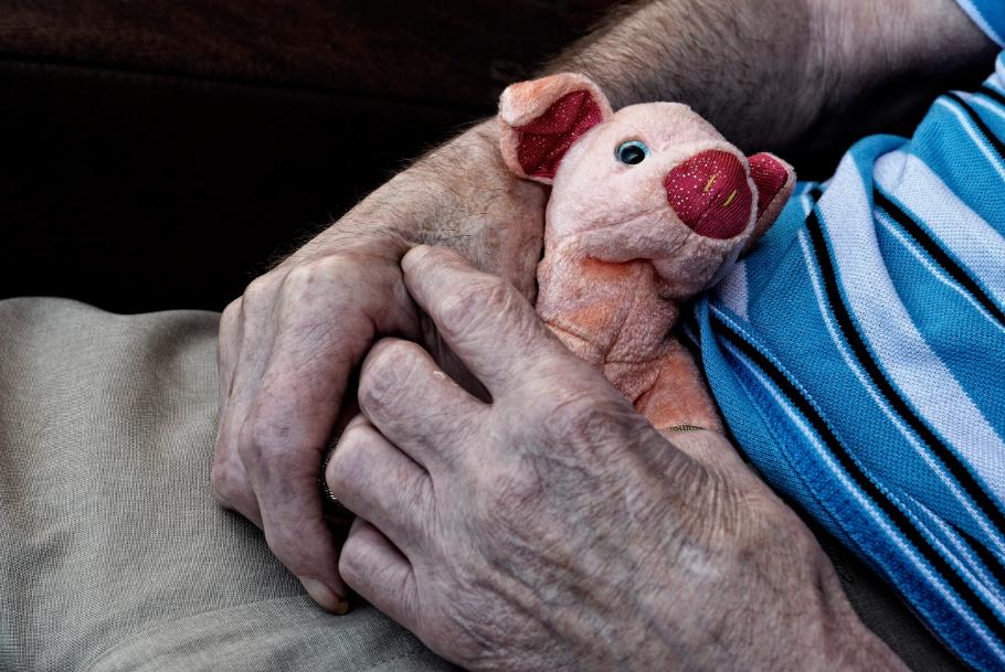 Elderly resident with a pig toy in lap