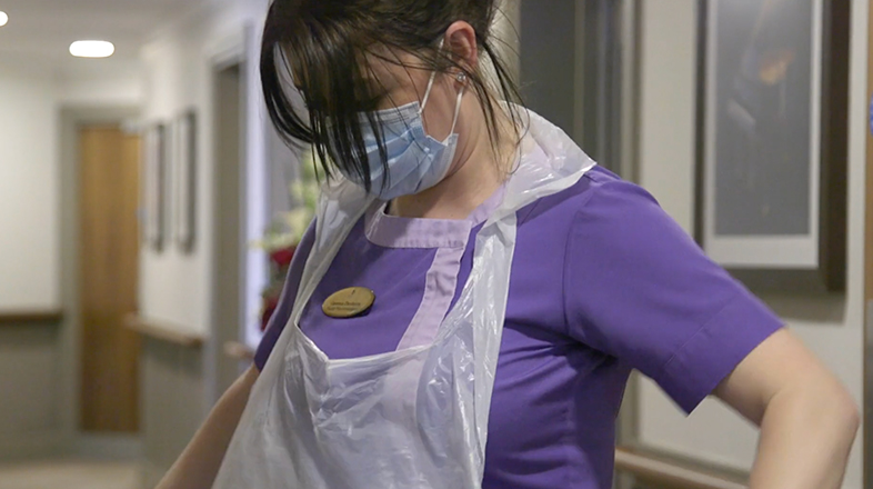 A carer wearing purple scrubs