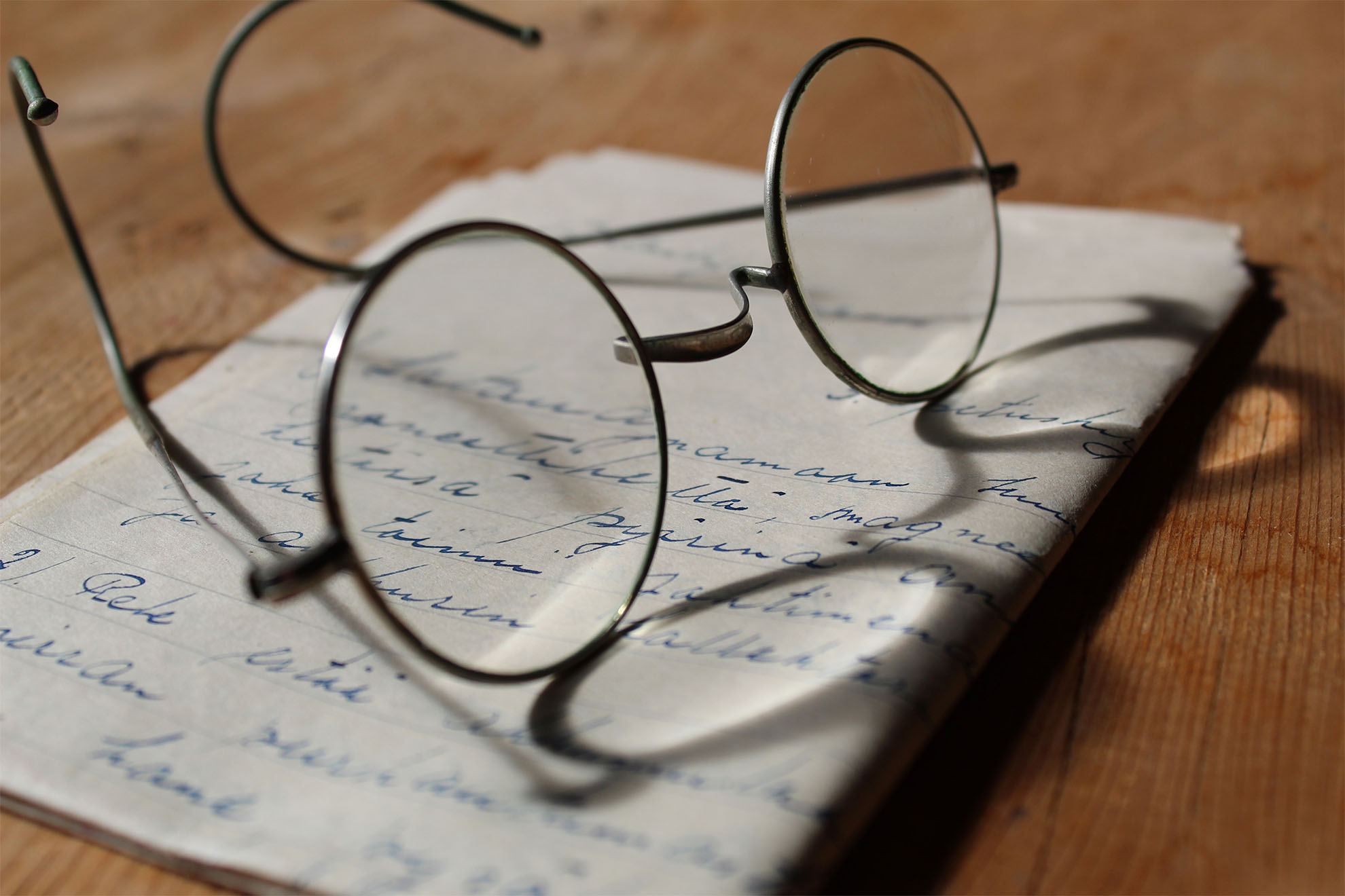 A pair of glasses resting on a handwritten letter