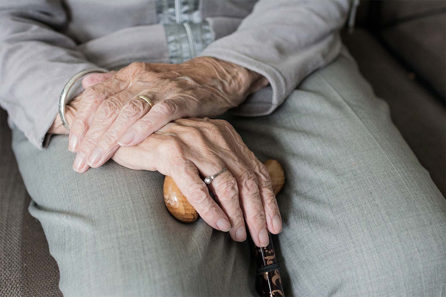 An elderly lady holding a walking stick