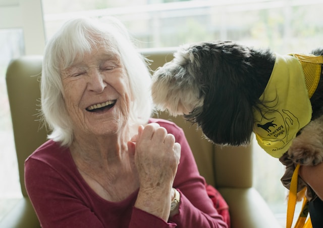 resident laughing with a therapy dog