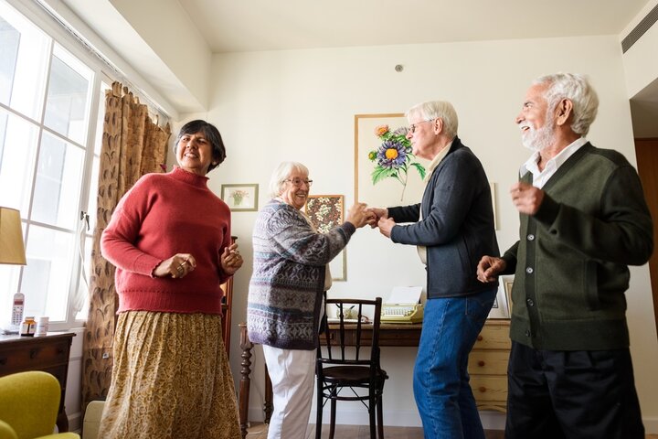 old people dancing in a care home lounge