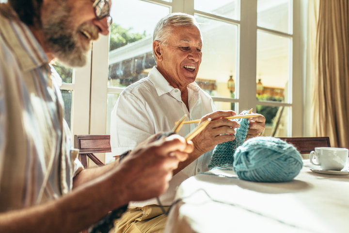 two men knitting in a care home