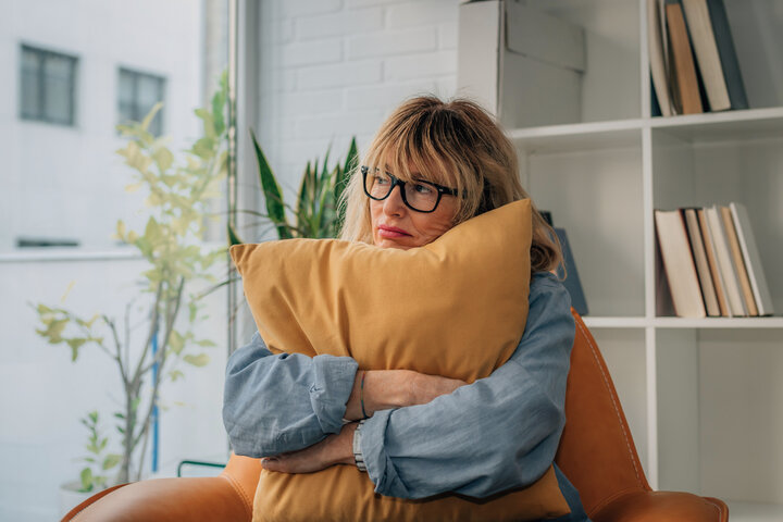 tired carer hugs a pillow