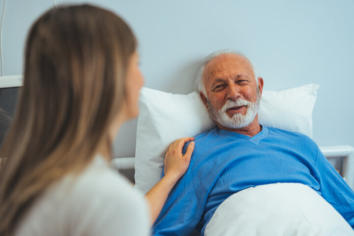 older man in bed with a visitor