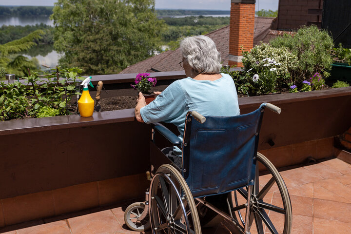 old woman in wheelchair doing some gardening at a care home